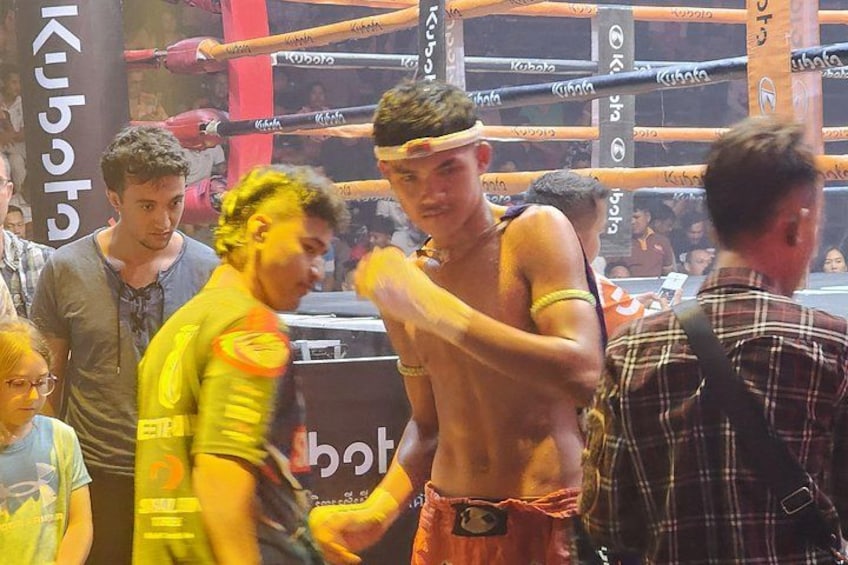 A boxing ring with a crowd of people around it. 4