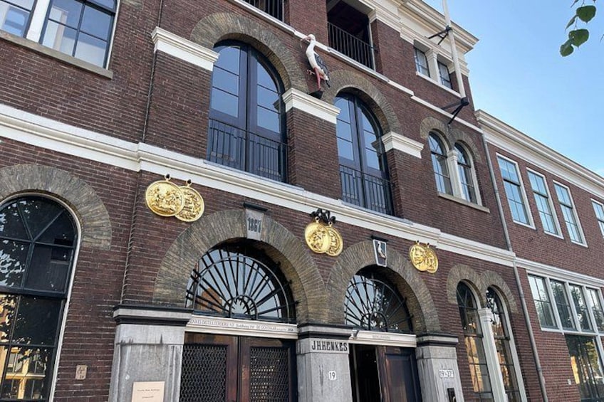 A historic building with arched windows, a large door, and a plaque. 4
