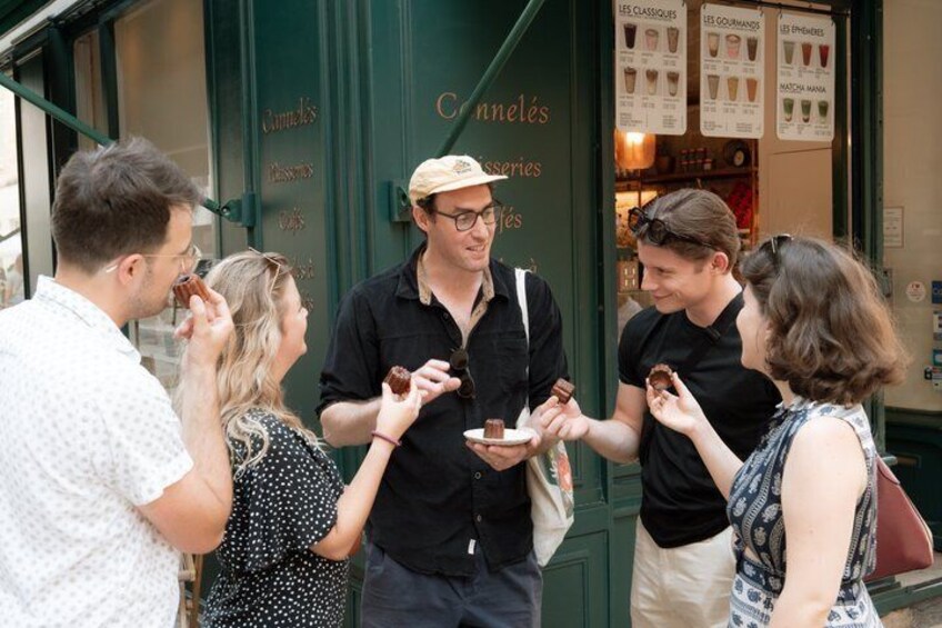 A group of people standing outside a shop with a menu board visible. 5