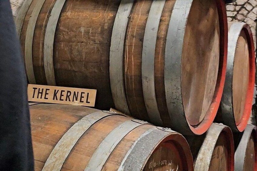 Wooden barrels stacked with a sign reading 'THE KERNEL'. 3