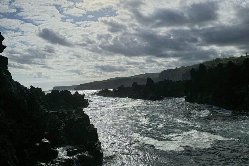 A coastal landscape with rocky cliffs and turbulent sea. 1