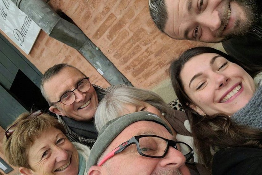 A group of people standing close together, possibly indoors. 5