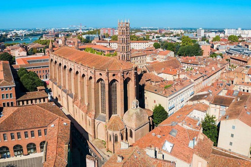 A cathedral with a tall spire, surrounded by urban buildings and a river in the background. 3