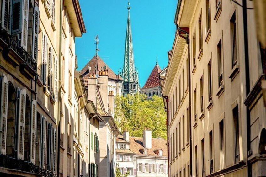 A street with buildings, a church spire, and a tower. 3