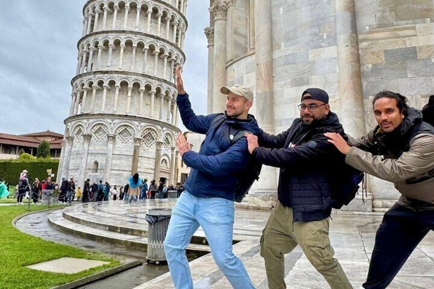 A group of people in front of the Leaning Tower of Pisa. 4