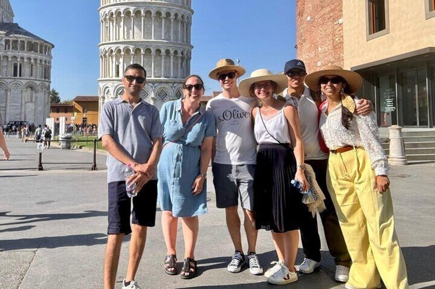 A group of people standing in front of the Leaning Tower of Pisa. 1