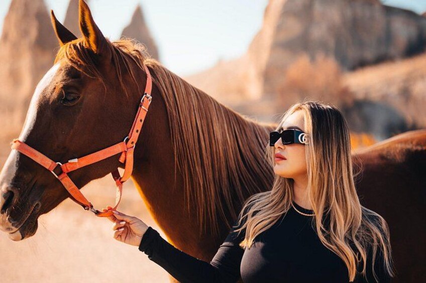 Una persona con un caballo en un paisaje desértico con formaciones rocosas. 2