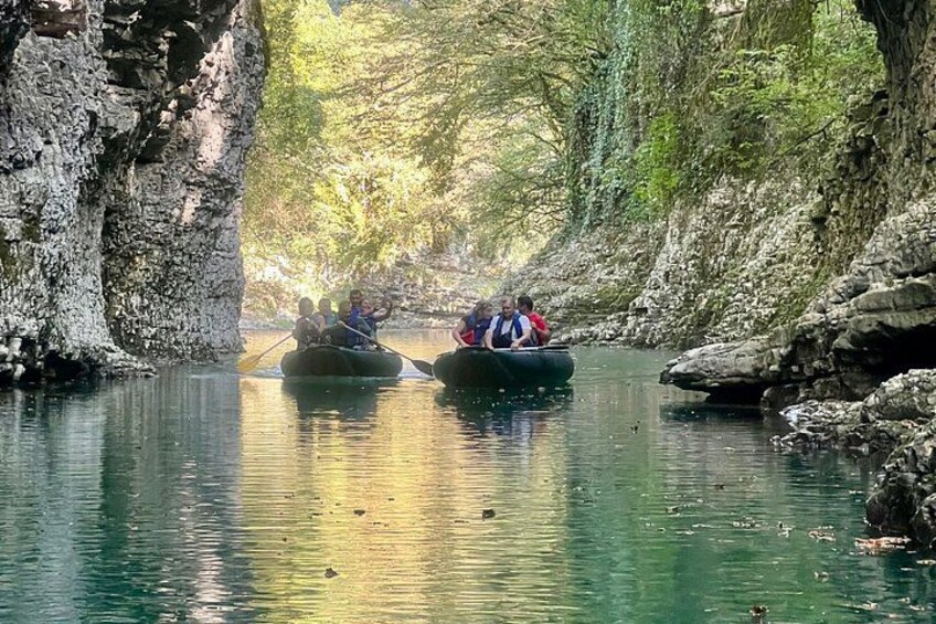 Deux personnes dans un bateau sur une rivière, entourées de falaises rocheuses et de verdure. 3