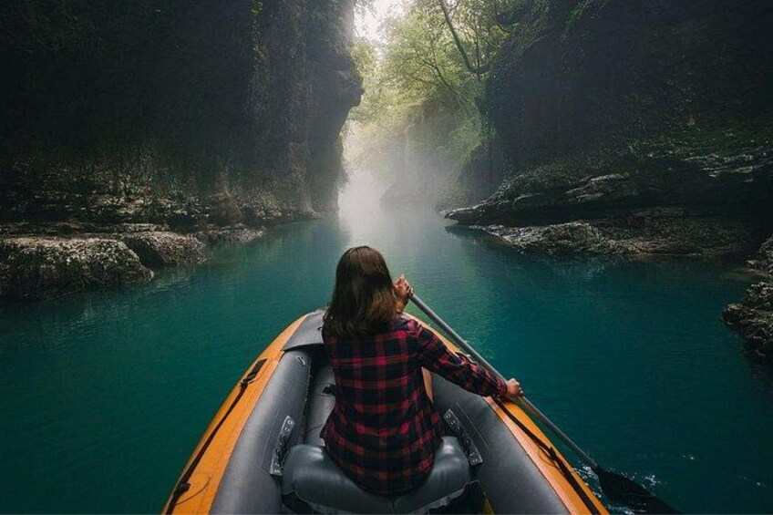 Une personne dans un kayak, sur une rivière bordée de falaises rocheuses. 1