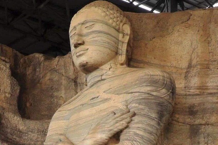A large stone statue with intricate carvings, set against a rocky background. 2