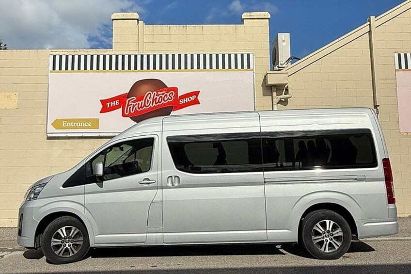 A silver van parked in front of a building with a sign that reads 'The Fruit Shop.' 3