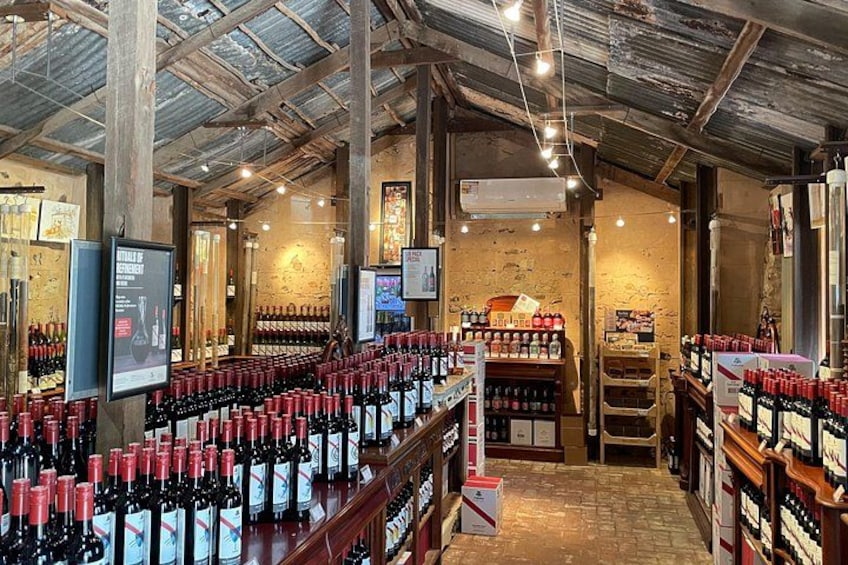 A wine cellar with rows of wine bottles, wooden shelves, and a rustic ceiling. 1