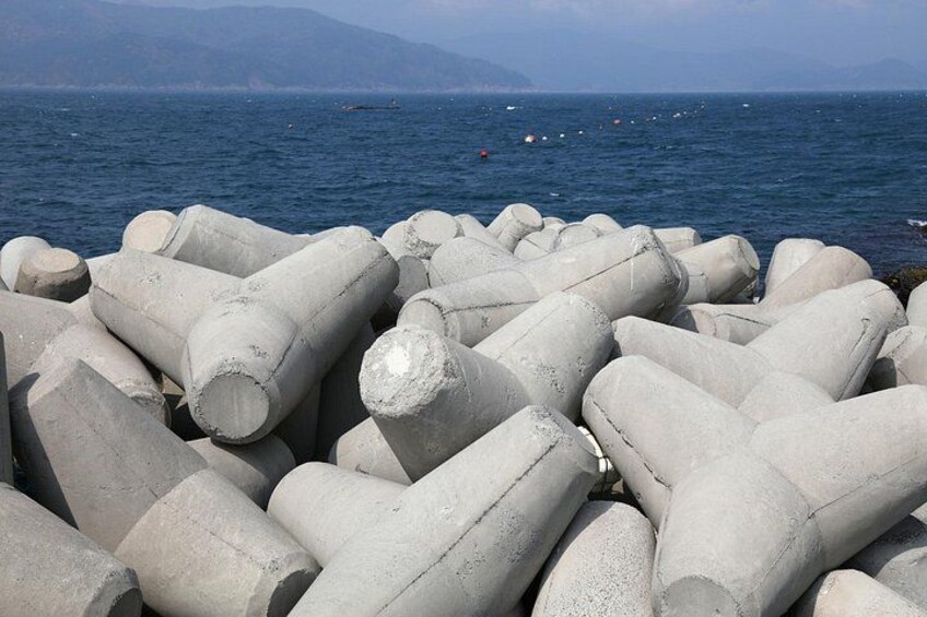 Un ensemble de grandes structures cylindriques en béton, situées au bord de la mer. 3