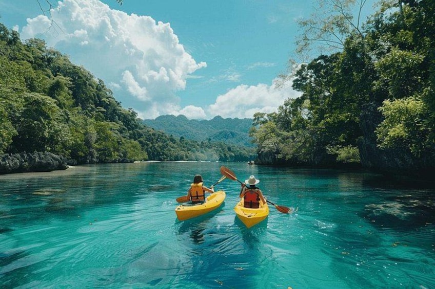 Dos personas hacen kayak en un río turquesa cristalino rodeado de vegetación exuberante y montañas. 1