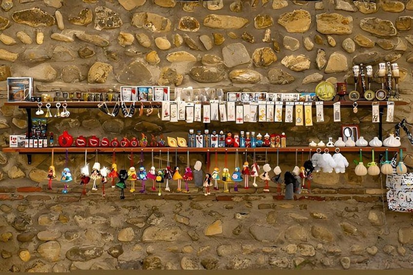 A stone wall with various items displayed on shelves, including figurines, bottles, and decorative objects. 2
