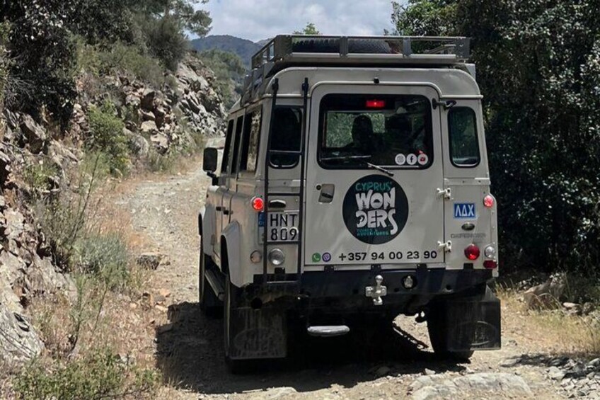 Un vehículo con placa HNT 809 estacionado en un camino de tierra rodeado de terreno rocoso y vegetación escasa. 2