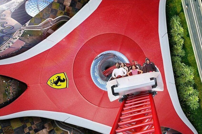 A red Ferris wheel with a Ferrari logo, a white gondola with passengers, and a circular structure in the center. 3