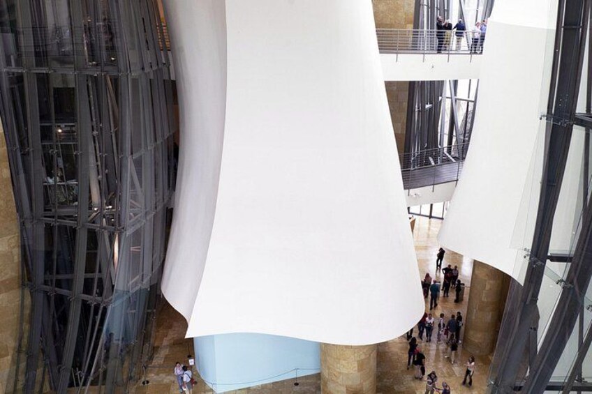 A modern architectural structure with large white panels and a central column. 2