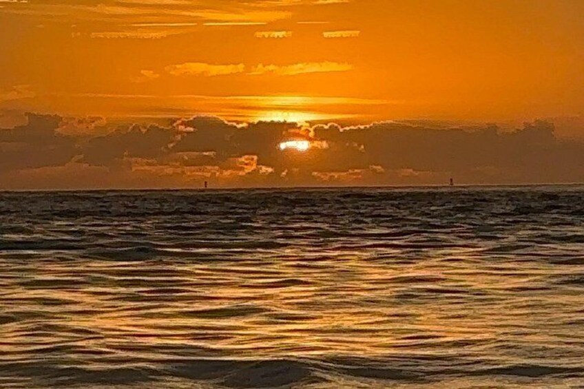 Un atardecer sobre el océano con olas reflejando la luz. 2