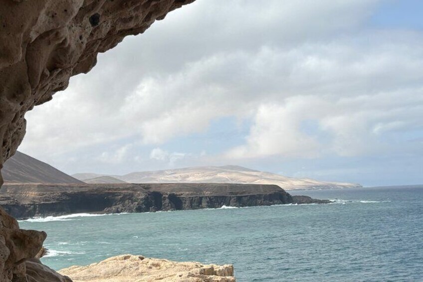 A coastal landscape with cliffs, ocean waves, and a clear sky. 5