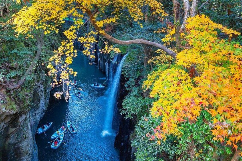 A river with boats, a waterfall, and autumn foliage. 3