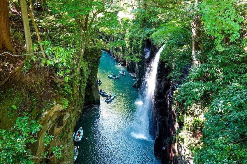 A river with a waterfall, surrounded by dense greenery and trees. 3