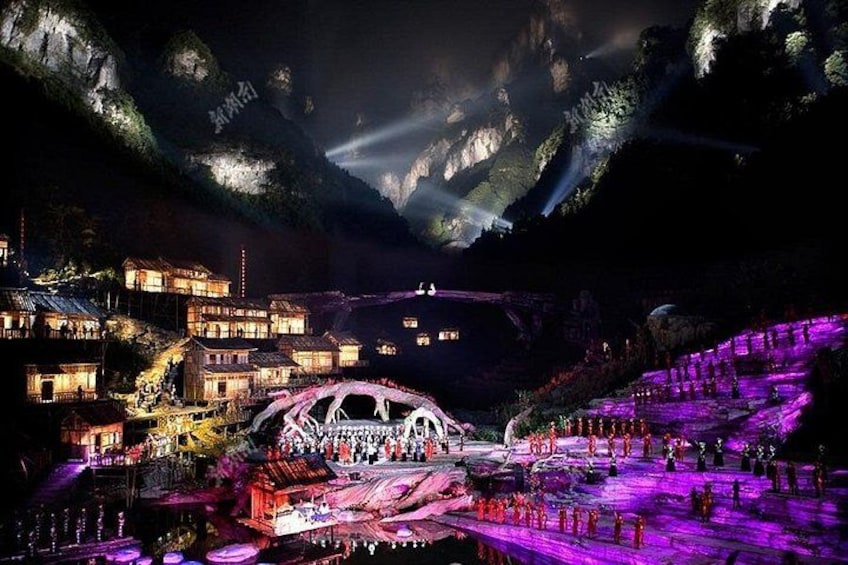 A mountainous village at night with illuminated buildings and a bridge. 1