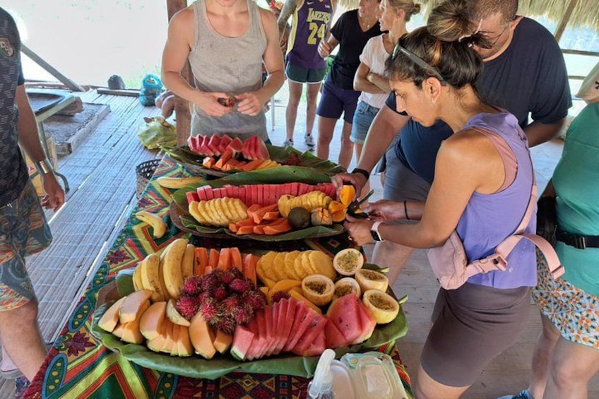 A group of people at a buffet with various fruits and vegetables on display. 3