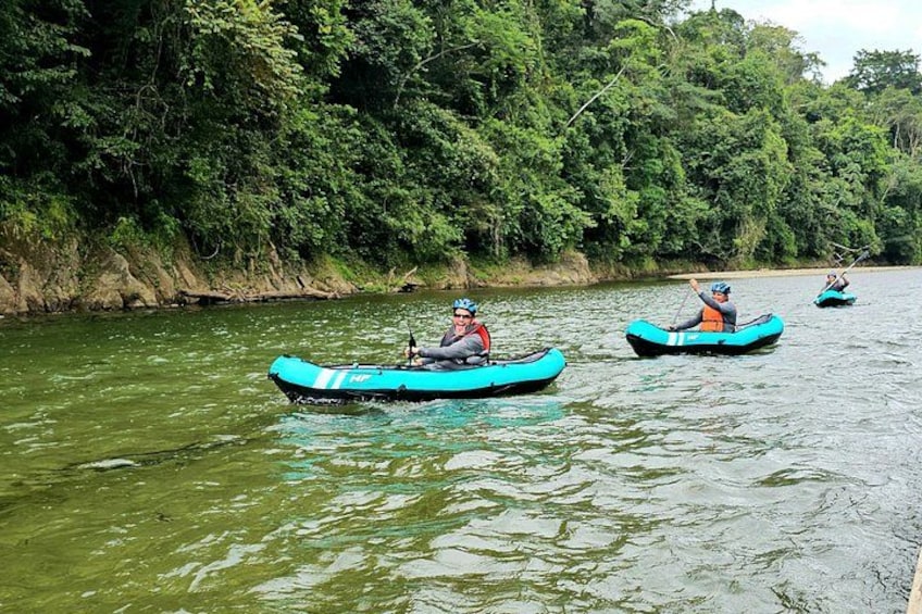 Trois kayaks sur une rivière, entourés d’une végétation luxuriante. 1