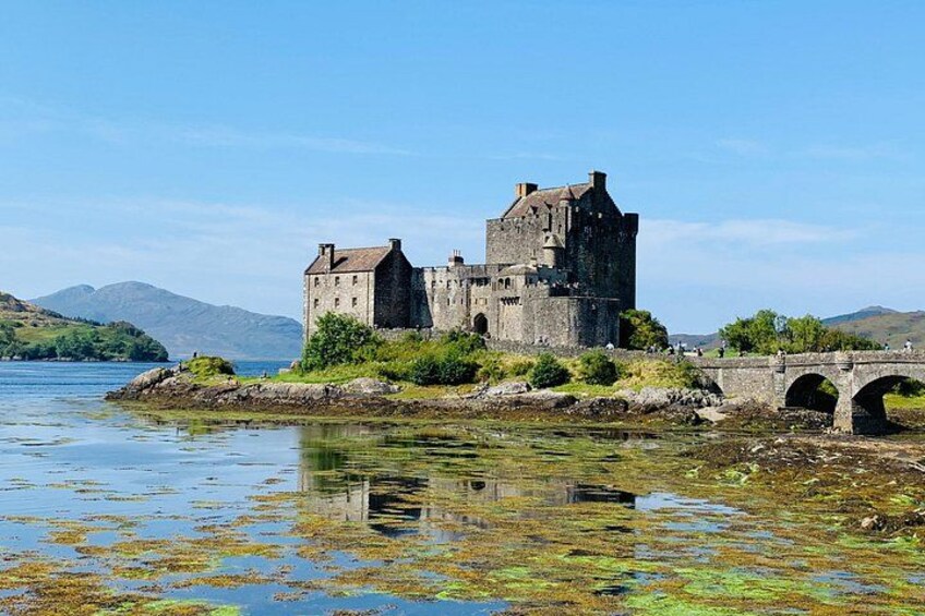 Eine historische Burg an einem See mit einer Brücke. 1