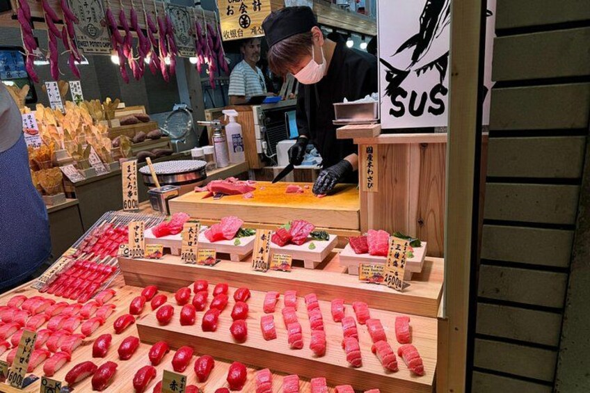 A sushi display with various types of sushi and a sign that says 'SUS'. 5