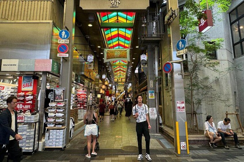 A pedestrian street with shops, colorful ceiling lights, and signs indicating pedestrian zones. 3