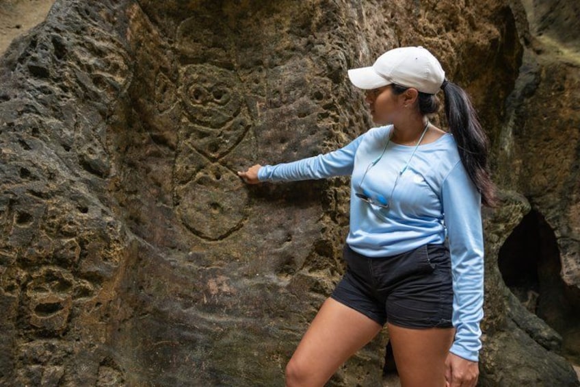 A person examining rock carvings. 2