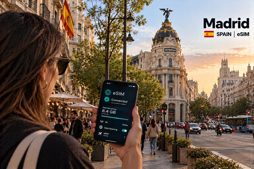 Una persona sosteniendo un teléfono inteligente que muestra conectividad eSIM en Madrid, España. 1
