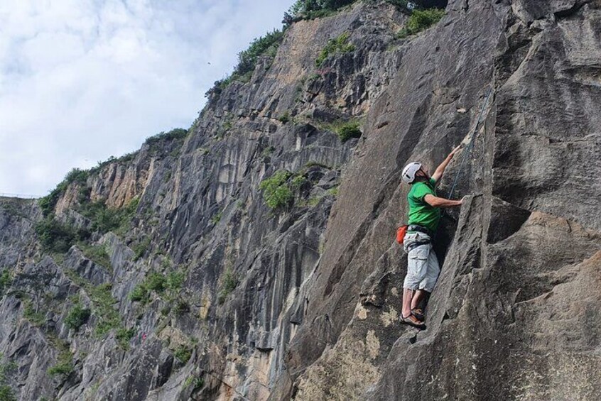Eine Person klettert an einer steilen Klippe. 1