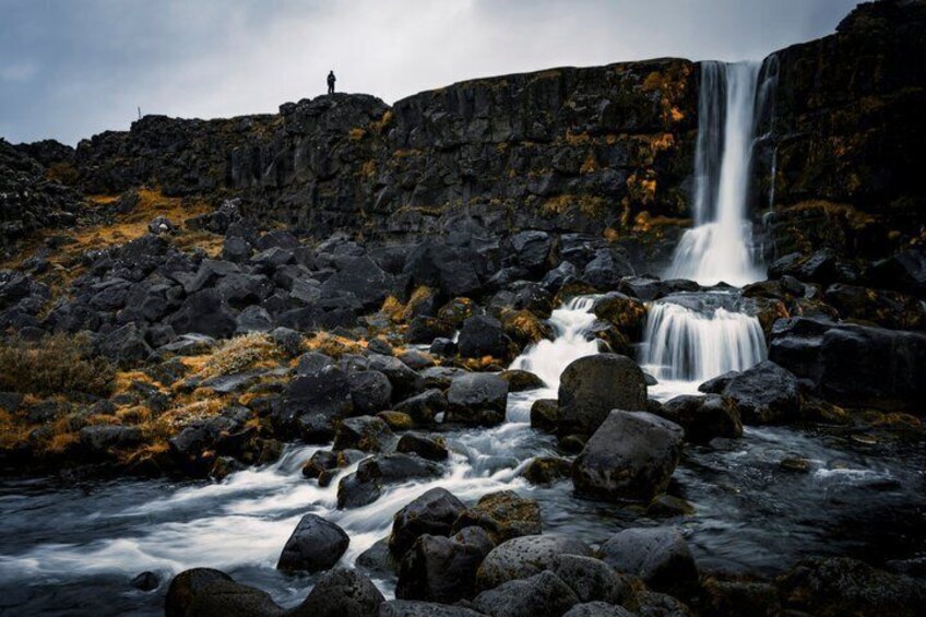 Ein Wasserfall stürzt über Felsen in einer zerklüfteten Landschaft. 3