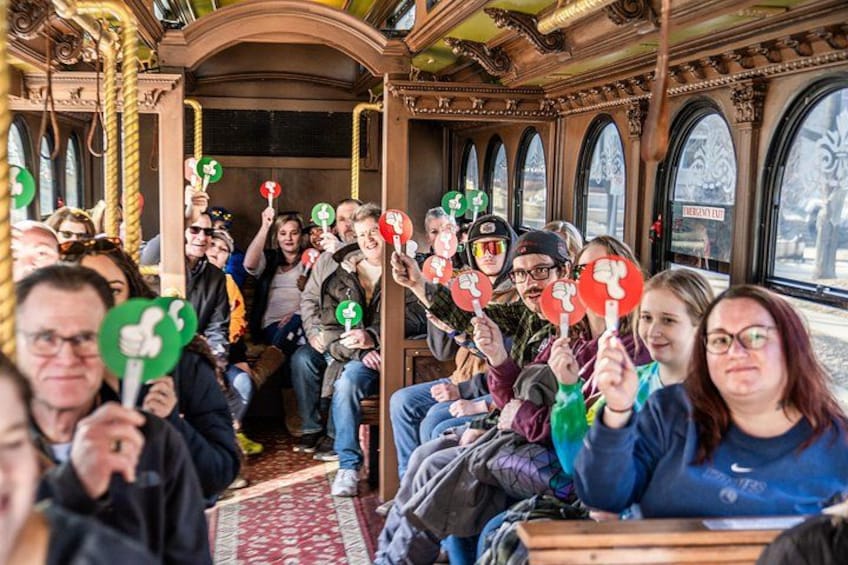 A vintage bus interior with passengers holding signs. 2