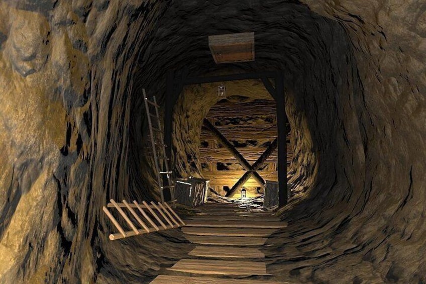 A narrow, wooden staircase leading into a cave with a wooden structure at the end. 4