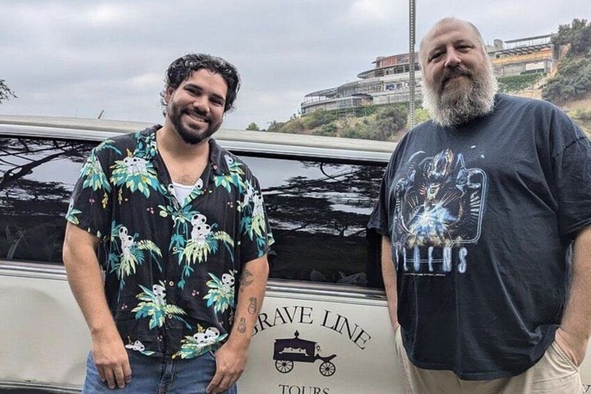 Due uomini in piedi davanti a un veicolo con un cartello 'GRAVE LINE TOURS'. 5