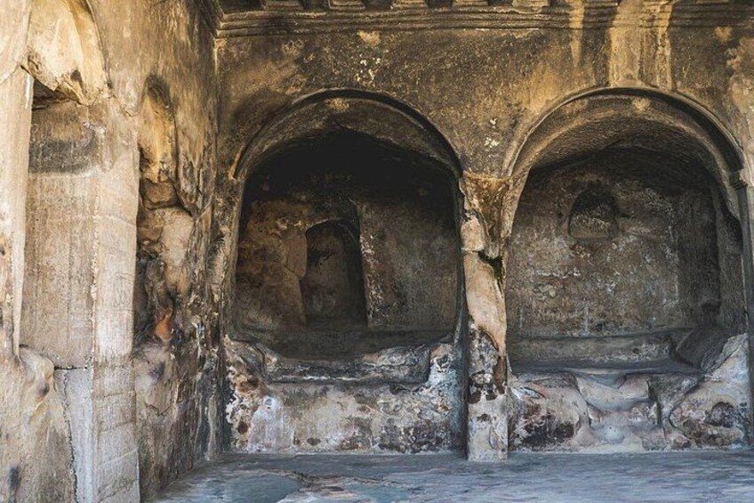An ancient stone structure with arched openings and weathered walls. 2