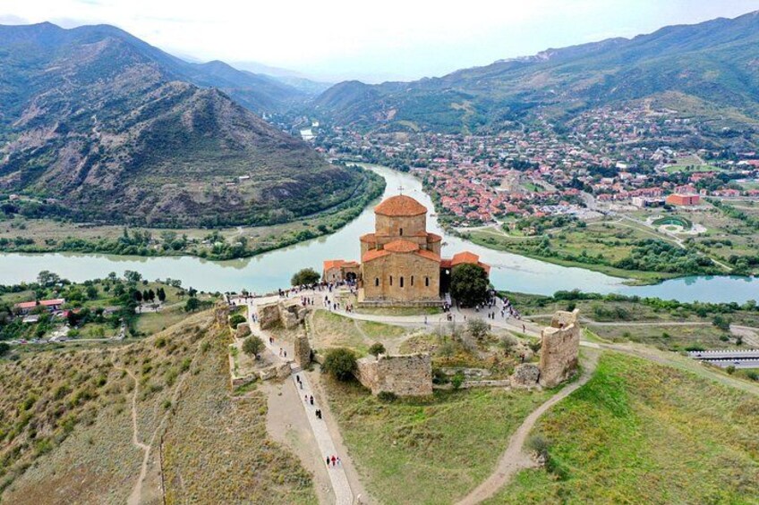 A historic church with a dome, surrounded by ruins and a river. 1