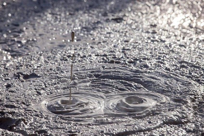 A water splash with ripples and a single droplet in motion. 4