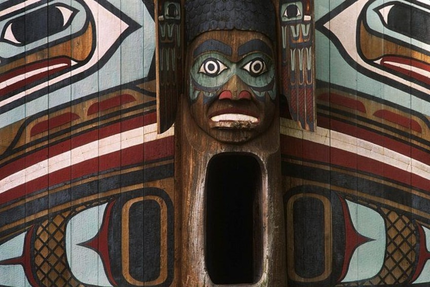 A totem pole with intricate carvings and a central face. 3
