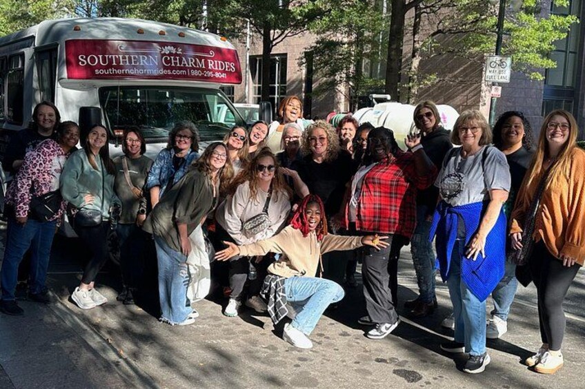 En gruppe mennesker poserer foran en bus med et skilt, der står 'SOUTHERN CHARM RIDES'. 1