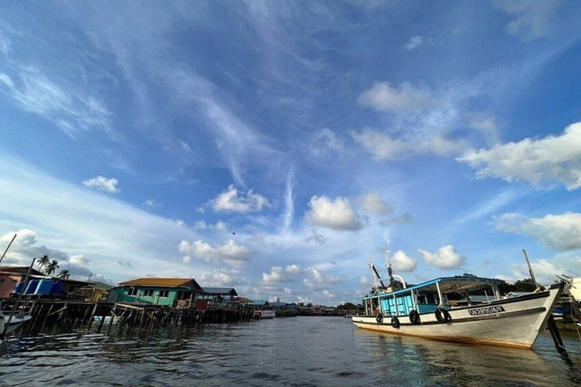 A boat docked at a pier with a clear sky and some clouds. 3