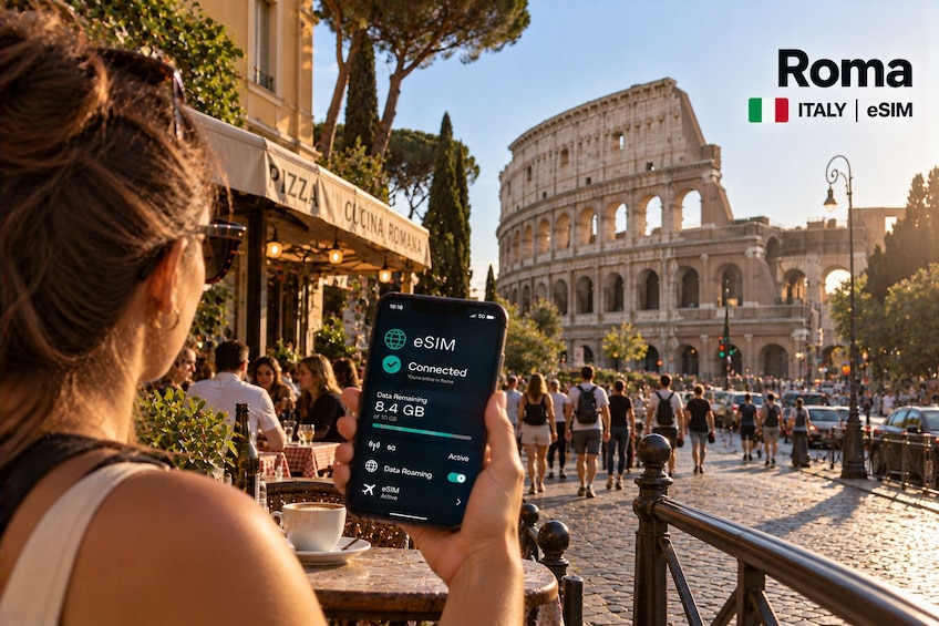 Une personne tenant un smartphone doté de la technologie eSIM à Rome, en Italie, avec le Colisée en arrière-plan. 1