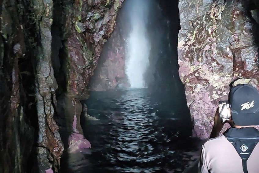 Una persona fotografiando una cascada dentro de una cueva. 1