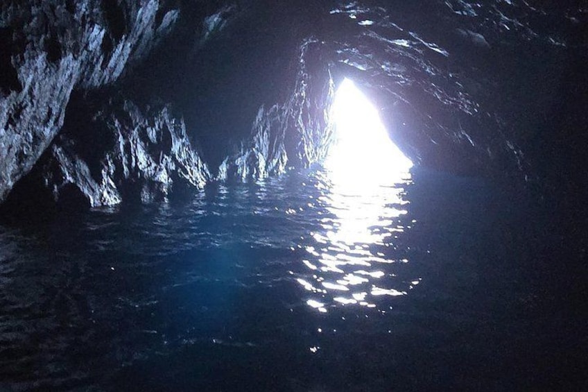 Entrada a una cueva con agua que refleja la luz. 3