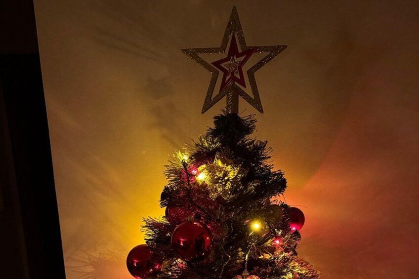 Ein Weihnachtsbaum mit Stern und roten Schmuckstücken. 2