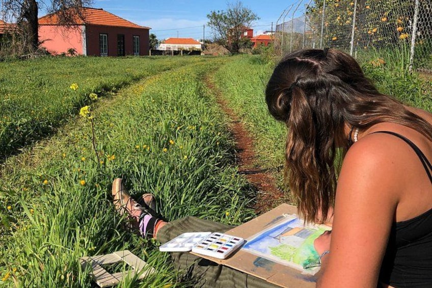 Iemand schildert een landschap met een schetsboek en aquarelverf. 4